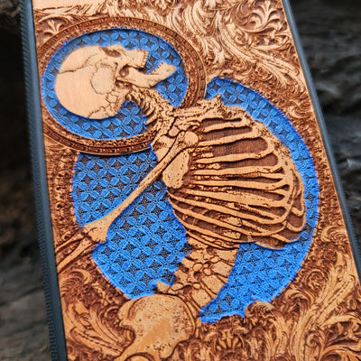Hand-finished cherry wood phone case with intricate laser-engraved Gothic skeleton art for iPhone & Samsung Galaxy.