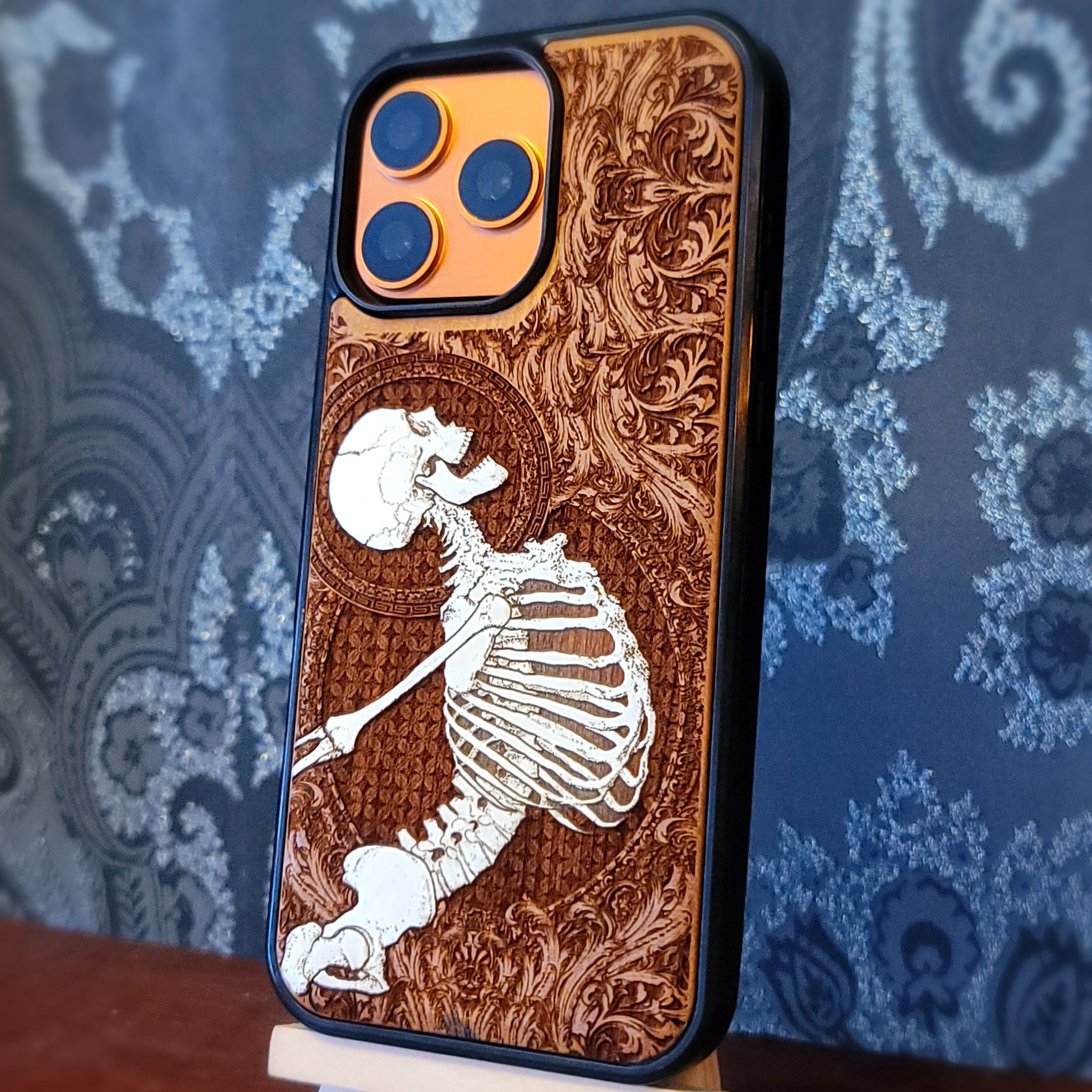 Deep laser engraved wooden phone case featuring a joyful human skeleton design on natural wood for iPhone and Samsung Galaxy.