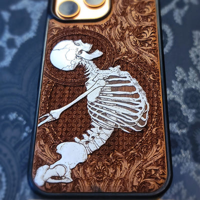Deep laser engraved wooden phone case featuring a joyful human skeleton design on natural wood for iPhone and Samsung Galaxy.