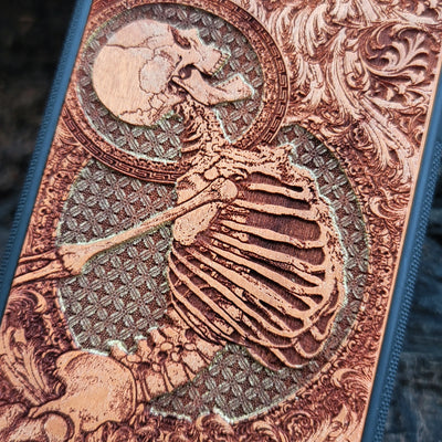 Hand-painted cherry wood phone case with intricate laser engraving of human skeleton and Gothic artwork.