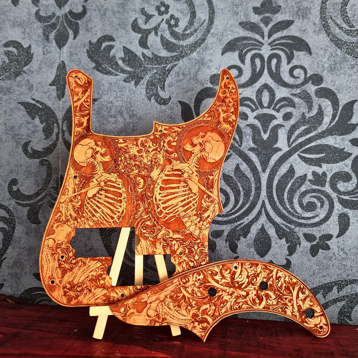 Precision Bass style wood pickguard with engraved skeleton artwork on cherry wood