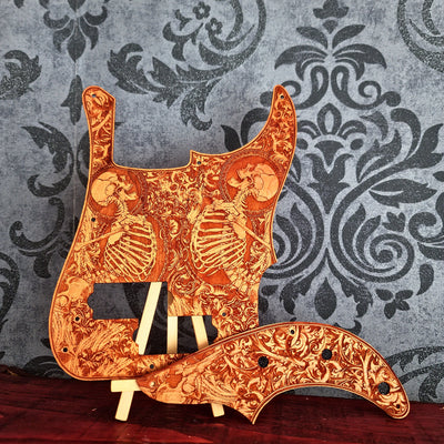 Precision Bass style wood pickguard with engraved skeleton artwork on cherry wood