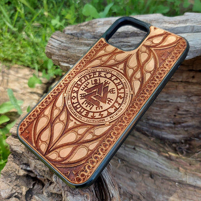 Viking-inspired wood phone case featuring the Valknut symbol surrounded by runes and intricate designs symbolizing courage, honor, and perseverance. Laser-engraved for precision and durability, this case is compatible with iPhone , 15, 14, 13, 12, 11, Pro Max, Mini, and Samsung Galaxy S, S24, S23, S22, S21, S20 Ultra, Plus, Note 20. A stylish and meaningful accessory for Norse mythology enthusiasts.