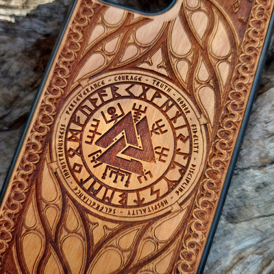 Viking-inspired wood phone case featuring the Valknut symbol surrounded by runes and intricate designs symbolizing courage, honor, and perseverance. Laser-engraved for precision and durability, this case is compatible with iPhone , 15, 14, 13, 12, 11, Pro Max, Mini, and Samsung Galaxy S, S24, S23, S22, S21, S20 Ultra, Plus, Note 20. A stylish and meaningful accessory for Norse mythology enthusiasts.
