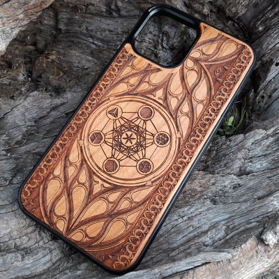 Wooden phone case featuring a laser-engraved Metatron's Cube design, intricately detailed with geometric patterns and mystical symbols. While the design itself is not specifically Lord of the Rings, its gothic and esoteric style creates a captivating, symbolic representation. Compatible with iPhone , 15, 14, 13, 12, 11 Pro Max Mini, and Samsung Galaxy S, S24, S23, S22, S21, S20 Ultra, Plus, and Note 20. A unique and protective accessory for those who appreciate geometric designs and spiritual symbolism.