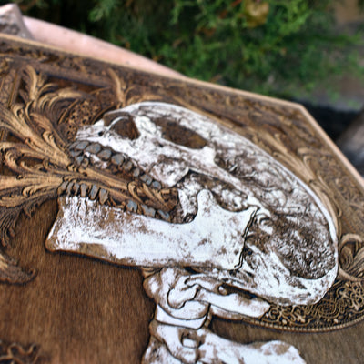 Horror-inspired wall art featuring a tormented skull and spine on rustic wood.