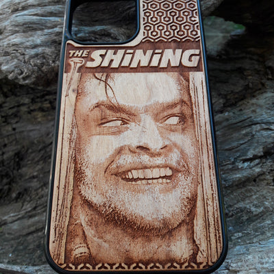 Wooden phone case featuring The Shining-inspired movie character design, intricately engraved, available for iPhone , Galaxy S, and more. Ideal for fans of classic horror films.