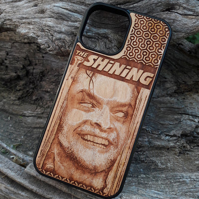 Wooden phone case featuring The Shining-inspired movie character design, intricately engraved, available for iPhone , Galaxy S, and more. Ideal for fans of classic horror films.