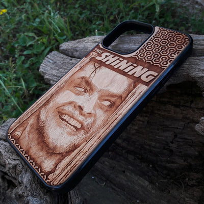 Wooden phone case featuring The Shining-inspired movie character design, intricately engraved, available for iPhone , Galaxy S, and more. Ideal for fans of classic horror films.