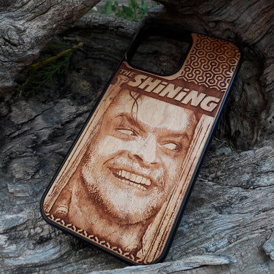 Wooden phone case featuring The Shining-inspired movie character design, intricately engraved, available for iPhone , Galaxy S, and more. Ideal for fans of classic horror films.