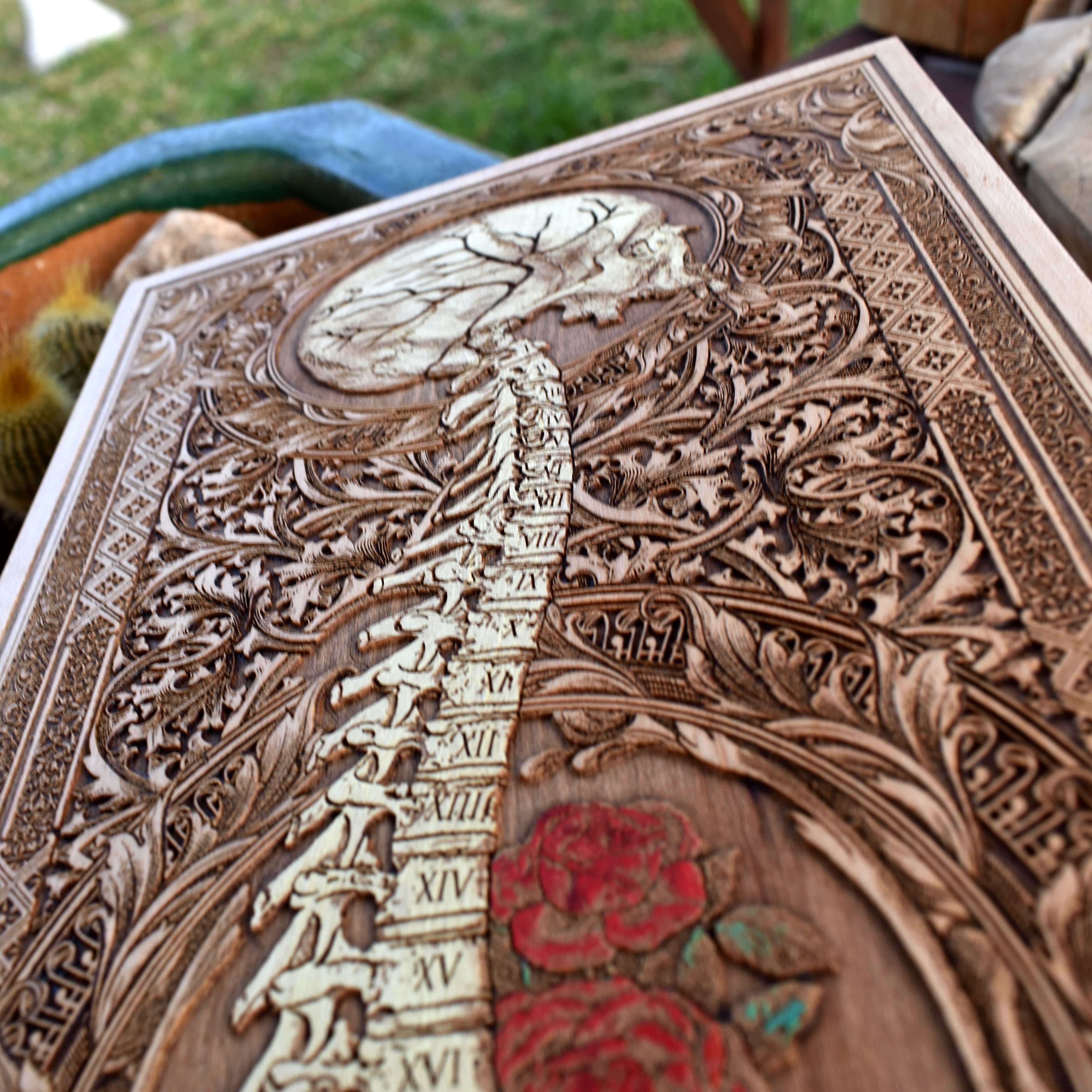 Engraved skull with numbered spine and floral details, gothic wood decor.