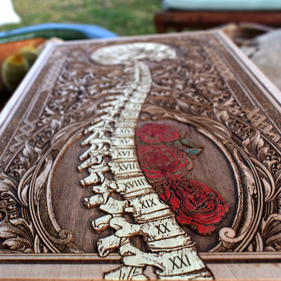 Unique gothic decor with Roman spine, human skull, and painted roses.