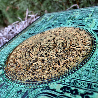 Detailed green Aztec sun stone carving on wood, perfect for cultural decor.