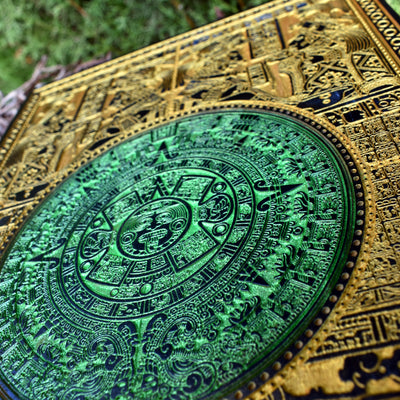 Boho-style Aztec calendar wall art, engraved and painted gold and green.