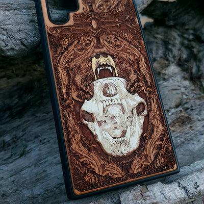 Laser-engraved bear skull design on a wooden phone case, featuring intricate gothic artwork, compatible with iPhone 16, iPhone 15, Galaxy S25, and more.
