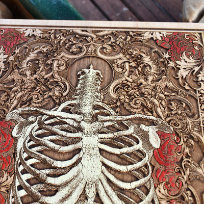 Macabre floral skeleton painting on natural wood, anatomical art piece.