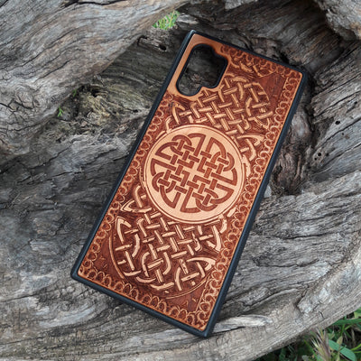 Laser-engraved wooden phone case showcasing a stunning Celtic knotwork design, intricately detailed for a timeless look. This durable and artistic case is compatible with iPhone , 15, 14, 13, 12, 11, Pro Max, Mini, and Samsung Galaxy S, S24, S23, S22, S21, S20 Ultra, Plus, Note 20. A perfect blend of craftsmanship and functionality for those who appreciate Celtic art.