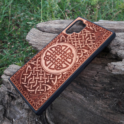 Laser-engraved wooden phone case showcasing a stunning Celtic knotwork design, intricately detailed for a timeless look. This durable and artistic case is compatible with iPhone , 15, 14, 13, 12, 11, Pro Max, Mini, and Samsung Galaxy S, S24, S23, S22, S21, S20 Ultra, Plus, Note 20. A perfect blend of craftsmanship and functionality for those who appreciate Celtic art.