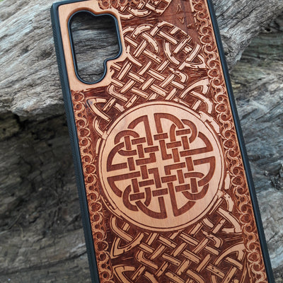 Laser-engraved wooden phone case showcasing a stunning Celtic knotwork design, intricately detailed for a timeless look. This durable and artistic case is compatible with iPhone , 15, 14, 13, 12, 11, Pro Max, Mini, and Samsung Galaxy S, S24, S23, S22, S21, S20 Ultra, Plus, Note 20. A perfect blend of craftsmanship and functionality for those who appreciate Celtic art.