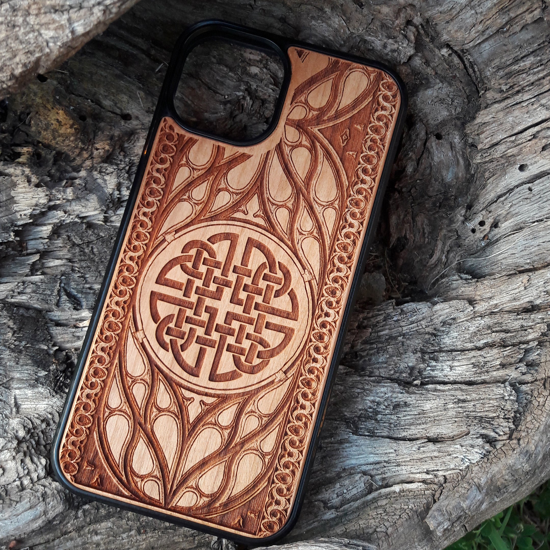 Wood phone case featuring a laser-engraved Celtic knot design surrounded by intricate Elvish-inspired patterns. Crafted for durability and elegance, this case is compatible with iPhone 16, 15, 14, 13, 12, 11, Pro Max, Mini, and Samsung Galaxy S25, S24, S23, S22, S21, S20 Ultra, Plus, Note 20. A stylish and protective accessory for fans of Celtic and Norse art.