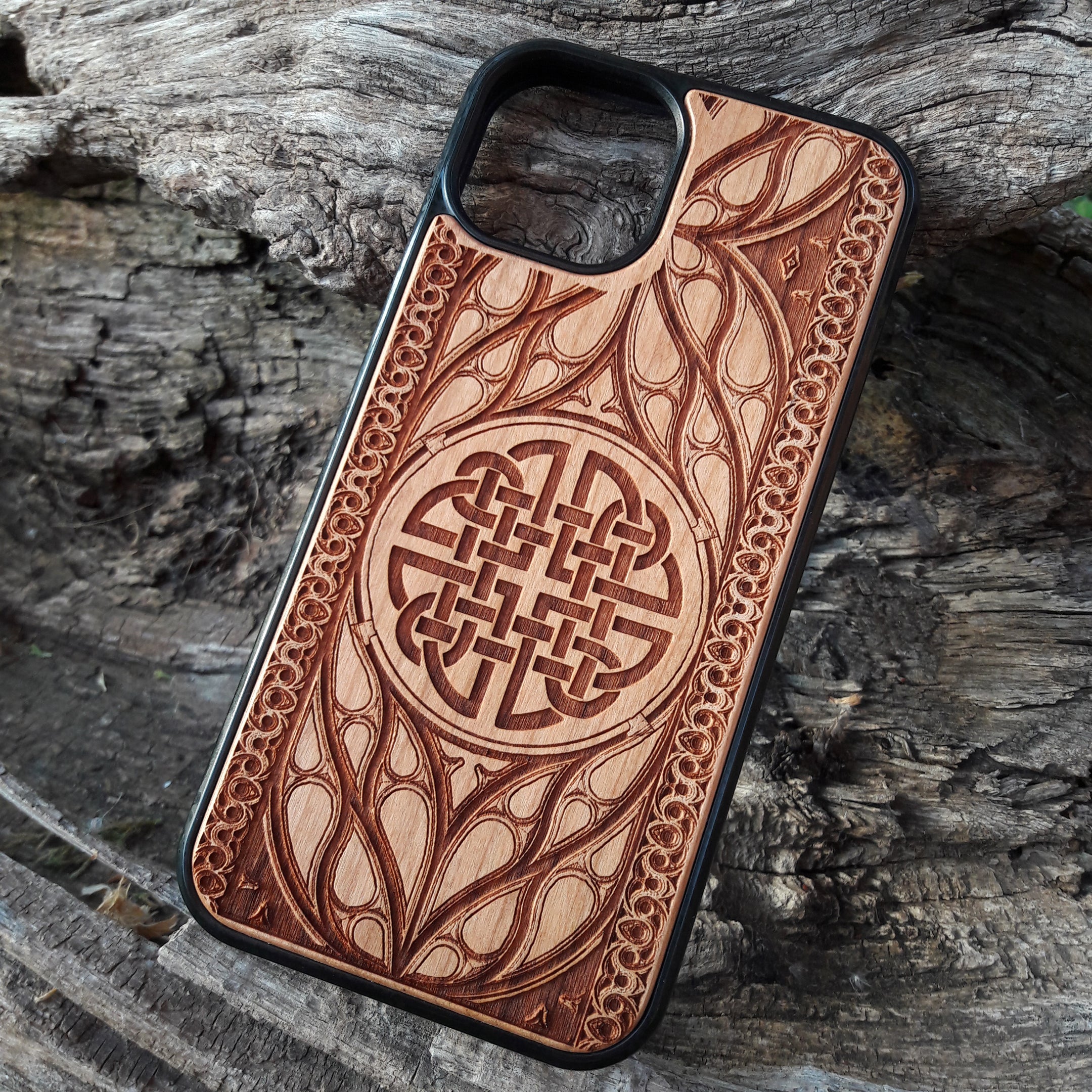Wood phone case featuring a laser-engraved Celtic knot design surrounded by intricate Elvish-inspired patterns. Crafted for durability and elegance, this case is compatible with iPhone 16, 15, 14, 13, 12, 11, Pro Max, Mini, and Samsung Galaxy S25, S24, S23, S22, S21, S20 Ultra, Plus, Note 20. A stylish and protective accessory for fans of Celtic and Norse art.