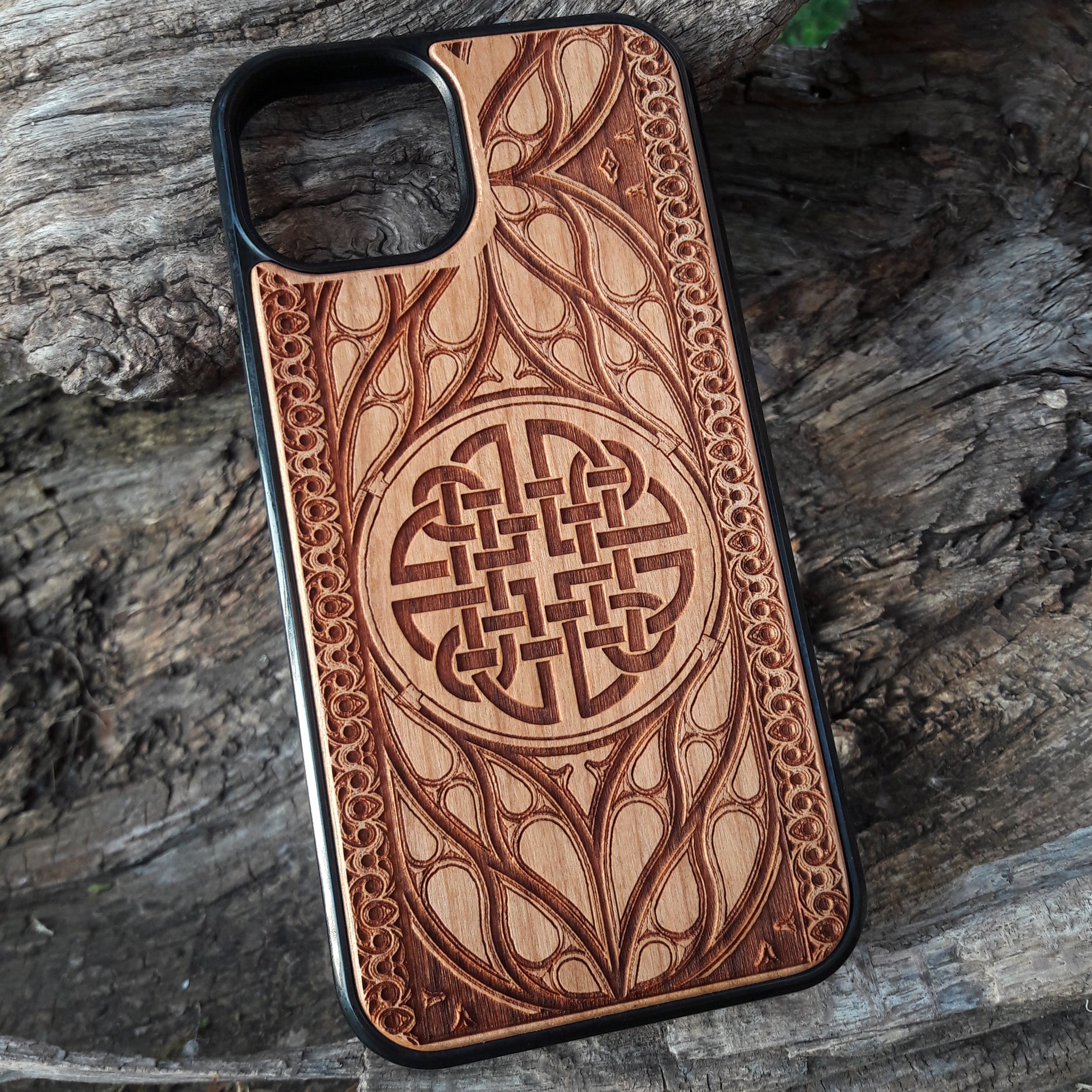 Wood phone case featuring a laser-engraved Celtic knot design surrounded by intricate Elvish-inspired patterns. Crafted for durability and elegance, this case is compatible with iPhone 16, 15, 14, 13, 12, 11, Pro Max, Mini, and Samsung Galaxy S25, S24, S23, S22, S21, S20 Ultra, Plus, Note 20. A stylish and protective accessory for fans of Celtic and Norse art.