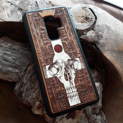 Laser-engraved wooden phone case featuring a gothic skull and cross design, compatible with iPhone 16, iPhone 15, Galaxy S25, and more