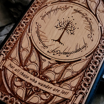 Lord of the Rings wood phone case featuring the White Tree of Gondor, Elvish script, and the iconic quote 'Not all those who wander are lost.' Laser-engraved with intricate detailing, this durable and elegant case is compatible with iPhone , 15, 14, 13, 12, 11, Pro Max, Mini, and Samsung Galaxy S, S24, S23, S22, S21, S20 Ultra, Plus, Note 20. A unique protective accessory for Tolkien fans.