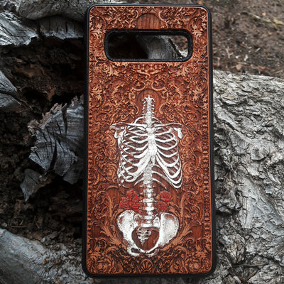 Laser-engraved anatomical human skeleton design on a wooden phone case, compatible with iPhone 16, iPhone 15, Galaxy S25, and more.