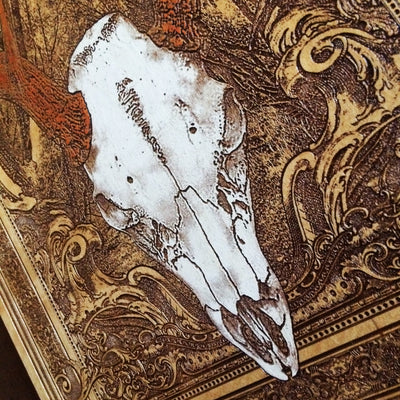 Deer skull and antlers engraved on dark cedar wood, rustic wall decor.