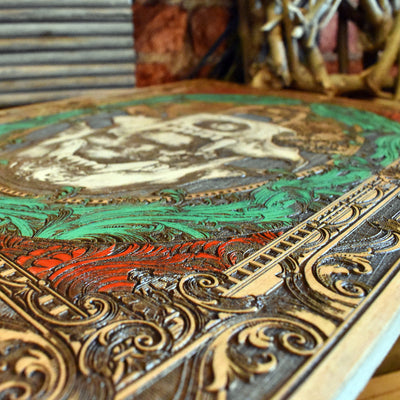 Close-up of bear skull wood engraving with dark hand-painted detail.