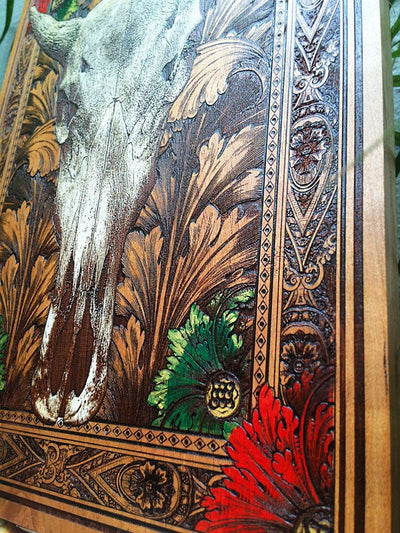 Detailed cow skull design on handcrafted cherry wood wall panel.