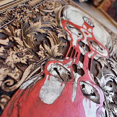 Symbolic gothic wall art with skulls and blood in hourglass, life and death theme.