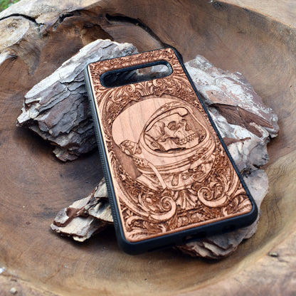 Wooden phone case with intricate engraved praying skeleton design, compatible with iPhone 16, iPhone 15, Samsung Galaxy S25, Note 20, and more. Perfect for gothic art lovers and unique phone accessories.