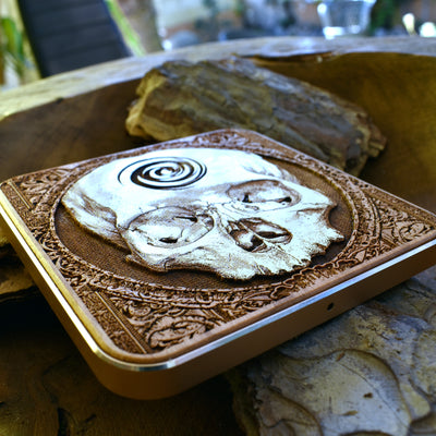 iPhone 16 resting on skull engraved wireless charger, fast and stylish gothic charging pad.