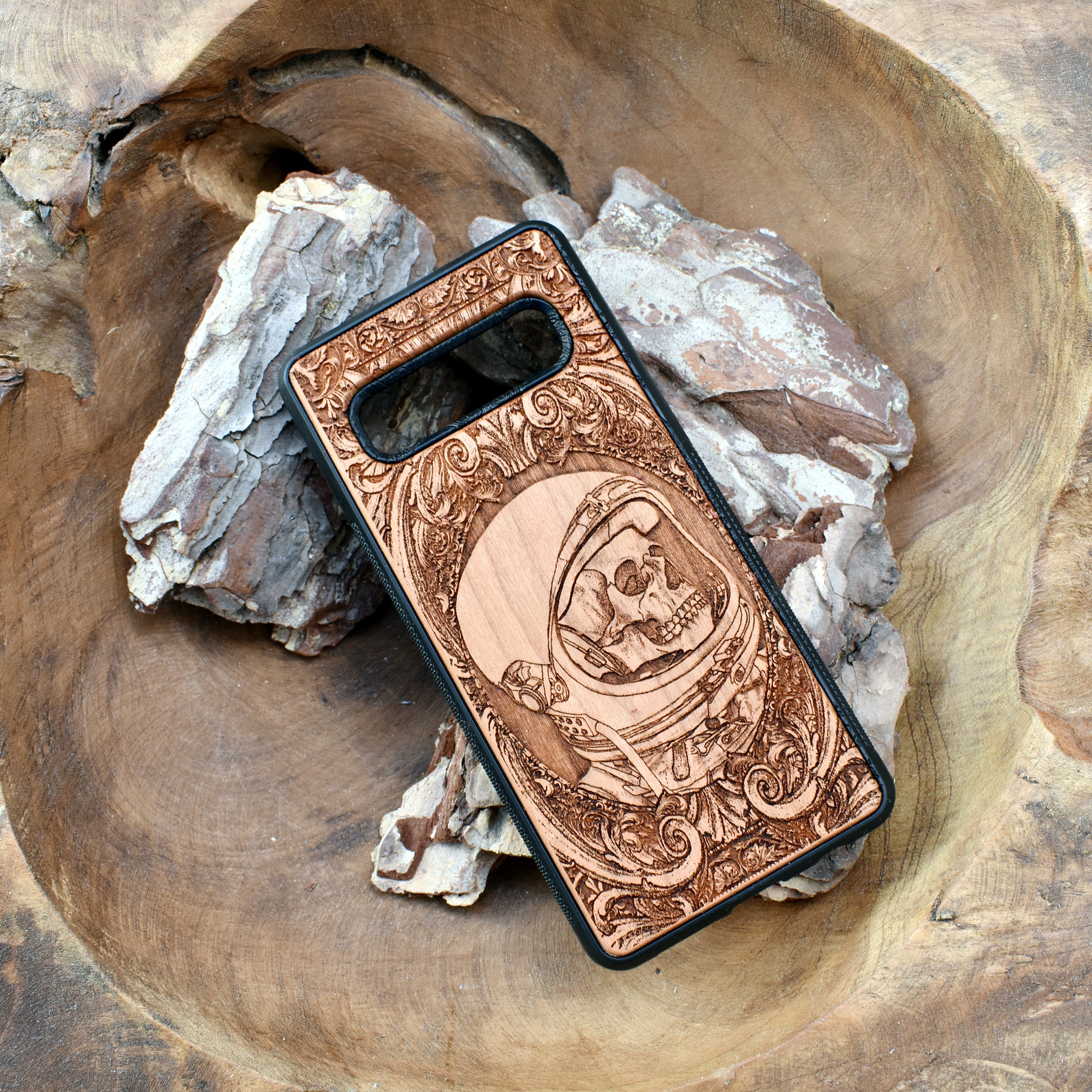 Wooden phone case with intricate engraved praying skeleton design, compatible with iPhone 16, iPhone 15, Samsung Galaxy S25, Note 20, and more. Perfect for gothic art lovers and unique phone accessories.