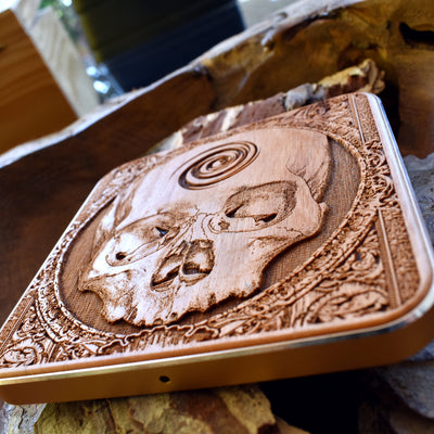 iPhone 16 wirelessly charging on skull engraved wood pad, gothic home office accessory with fast charging.