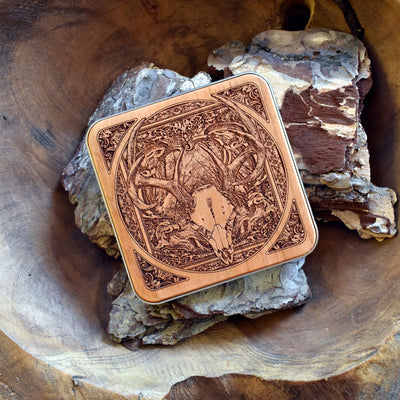 Close-up of detailed laser-engraved deer skull on wood wireless charging pad.