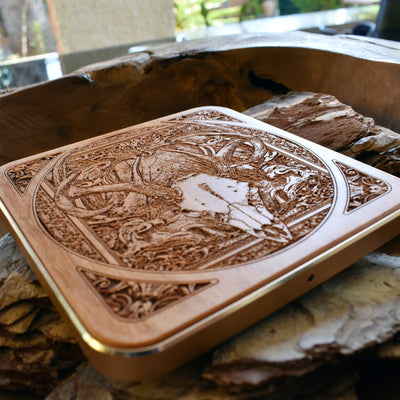Slim-profile wood wireless charger with bold deer skull engraving for artistic workspaces.