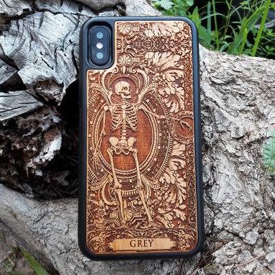 Laser-engraved wooden phone case featuring a detailed skull design, compatible with iPhone 16, iPhone 15, Galaxy S25, and more