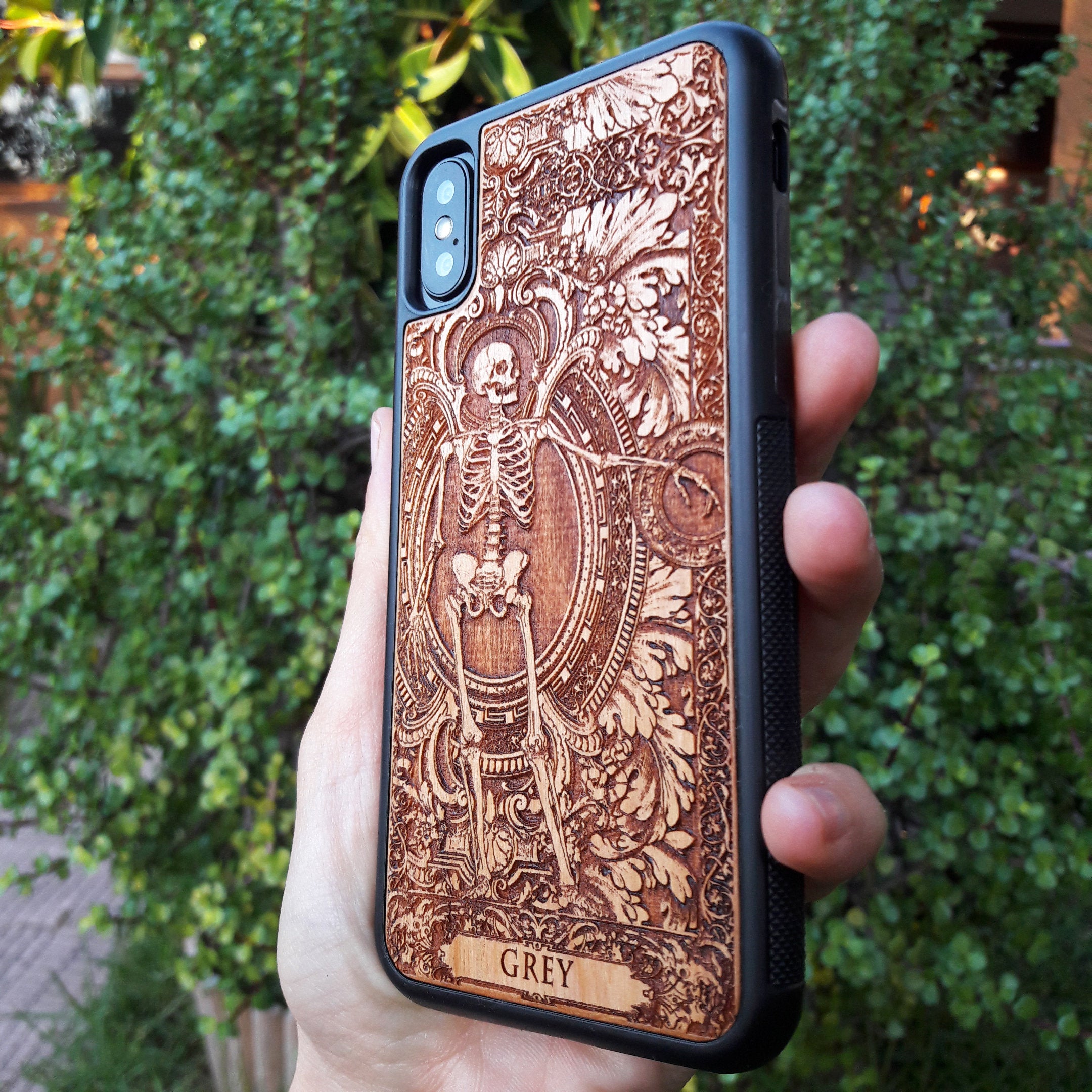 Personalized wood phone case featuring a skeleton design with custom names "Michelle" and "Jannik," ideal for iPhone 16 and Samsung Galaxy S25 users looking for unique and durable phone protection.