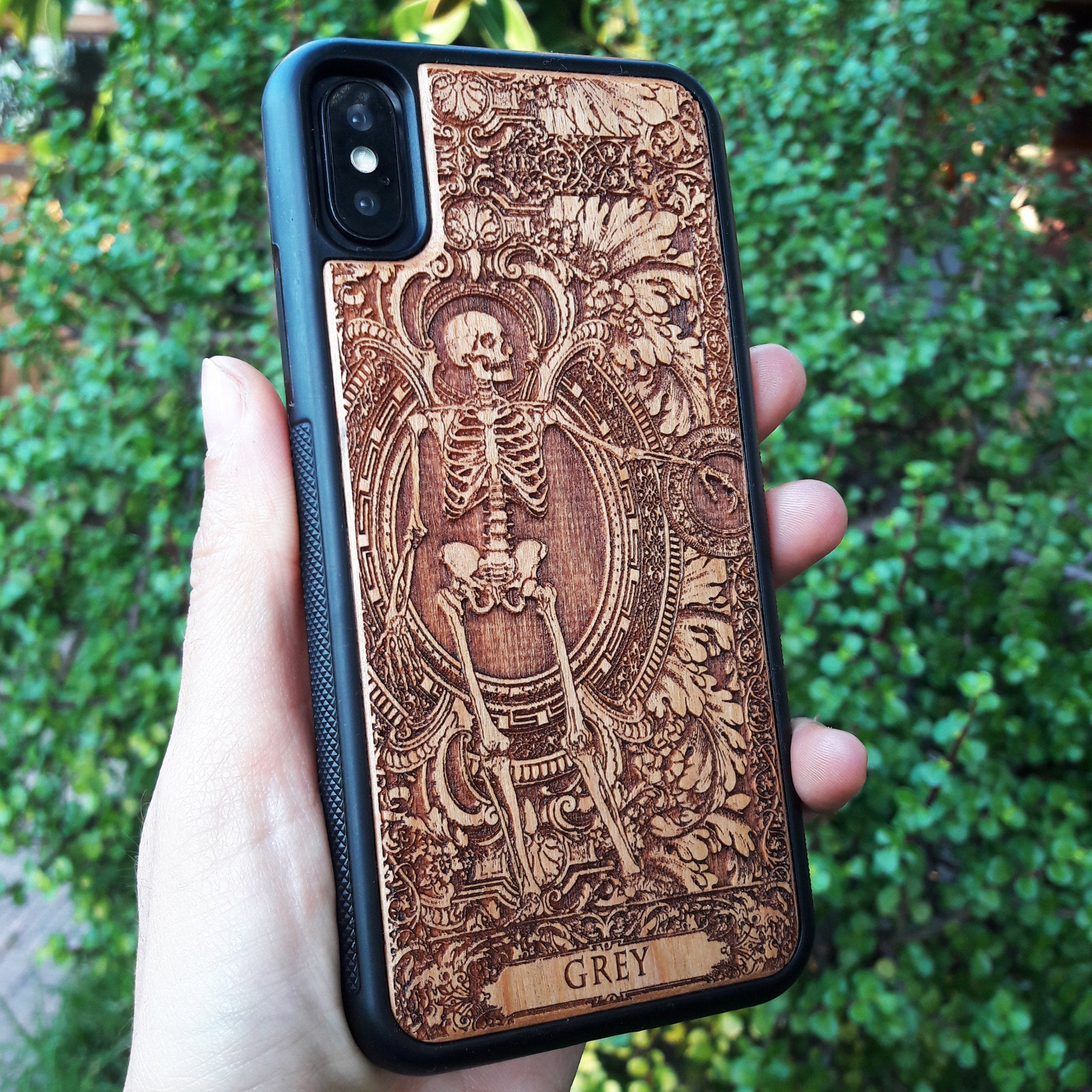 Personalized wood phone case featuring a skeleton design with custom names "Michelle" and "Jannik," ideal for iPhone 16 and Samsung Galaxy S25 users looking for unique and durable phone protection.