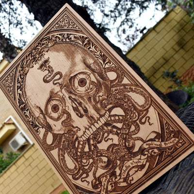 Engraved wooden wall art featuring a gothic Cthulhu skull