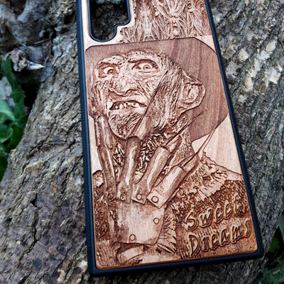 Freddy Krueger wood phone case with a laser-engraved design, showing Freddy's menacing face and "Sweet Dreams" inscription. Compatible with iPhone  and Samsung Galaxy S, the case features a detailed, horror-themed engraving perfect for fans of A Nightmare on Elm Street.