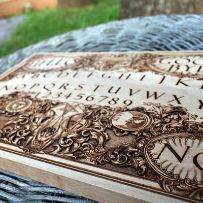 Dark aesthetic wooden Ouija board with eerie occult symbols.