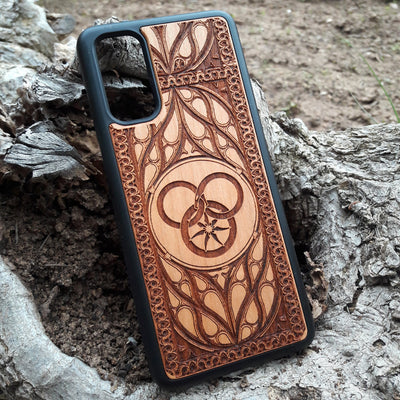 Wheel of Time-inspired wood phone case, laser-engraved with the iconic Aes Sedai symbol and intricate patterns. Made from premium wood for durability and elegance, this case is compatible with iPhone , 15, 14, 13, 12, 11, Pro Max, Mini, and Samsung Galaxy S, S24, S23, S22, S21, S20 Ultra, Plus, Note 20. A perfect accessory for fans seeking a unique and protective design.