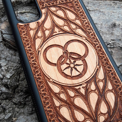 Wheel of Time-inspired wood phone case, laser-engraved with the iconic Aes Sedai symbol and intricate patterns. Made from premium wood for durability and elegance, this case is compatible with iPhone , 15, 14, 13, 12, 11, Pro Max, Mini, and Samsung Galaxy S, S24, S23, S22, S21, S20 Ultra, Plus, Note 20. A perfect accessory for fans seeking a unique and protective design.