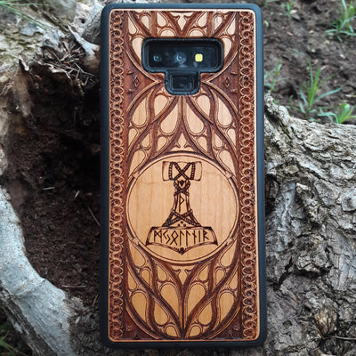Eco friendly wood phone case carved with a beautiful carved Mjolnir the Hammer of Thor design. Quality sustainable wooden handcrafted and laser engraved covers.Available for: iPhone 11,12,13,14 Pro Max, Mini, Plus and Samsung Galaxy S20, S21, S22, Plus, Ultra, Note 20, Note 10