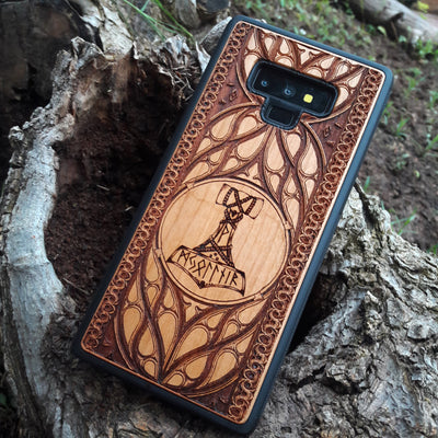 Eco friendly wood phone case carved with a beautiful carved Mjolnir the Hammer of Thor design. Quality sustainable wooden handcrafted and laser engraved covers.Available for: iPhone 11,12,13,14 Pro Max, Mini, Plus and Samsung Galaxy S20, S21, S22, Plus, Ultra, Note 20, Note 10