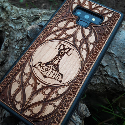 Eco friendly wood phone case carved with a beautiful carved Mjolnir the Hammer of Thor design. Quality sustainable wooden handcrafted and laser engraved covers.Available for: iPhone 11,12,13,14 Pro Max, Mini, Plus and Samsung Galaxy S20, S21, S22, Plus, Ultra, Note 20, Note 10